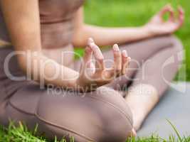 Start your day the calm way. Closeup shot of an unrecognisable woman meditating outdoors.