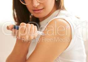 Diabetes is very manageable these days. Closeup shot of an unrecognizable woman injecting herself in the arm with insulin at home.