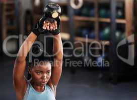 Giving up is not an option. a woman working out with a kettle bell at the gym.