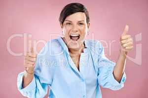 I couldnt be more in agreement. Cropped portrait of an attractive young woman giving you two thumbs in studio against a pink background.