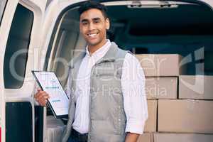 Christmas came early this year. a delivery man standing with a his clipboard by a delivery van stacked with boxes.