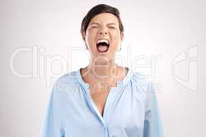 Release the rage. an attractive young woman shouting in studio against a grey background.