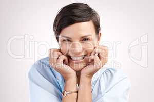 No hiding this smile. Cropped portrait of an attractive young woman posing in studio against a grey background.