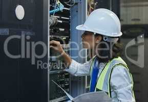 Leave it to women if you want it well done. a young woman working on cables in a server room.
