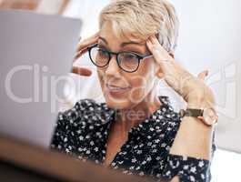 Oh look, I did it again. a mature woman sitting alone and feeling stressed while using her laptop to work from home.