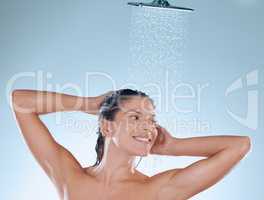 So clean, so fresh, and ready to face the day. Studio shot of a young woman taking a shower against a blue background.