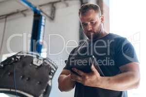 This tool helps us test your car parts without disassembling your vehicle. a mechanic using a digital tablet while working in an auto repair shop.