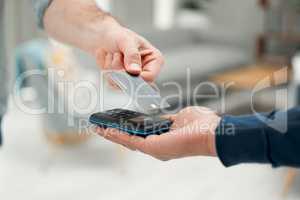 As simple as a tap. Closeup shot of an unrecognizable man paying his bills via wireless card reader.