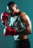 Stay ready for whatever comes your way. a handsome young man boxing against a studio background.