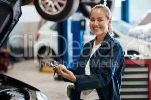 We offer both minor and major services depending on your needs. a female mechanic holding a clipboard while working in an auto repair shop.