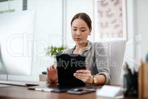 A customer just sent me an interesting brief. a young businesswoman using her digital tablet in her office.