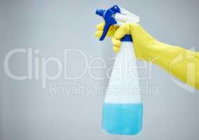 This will get rid of those tough stains. a hand holding a spray bottle and wearing yellow gloves.