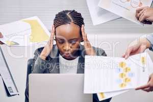 Its a never-ending workload. an attractive young businesswoman looking stressed while being presented paperwork by multiple hands.
