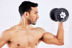 Believe in yourself and youll achieve it all. a young man flexing his bicep muscles while holding a weight against a studio background.