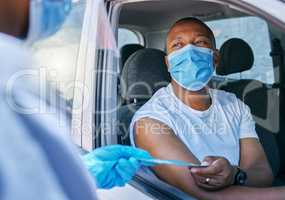 Drive thru covid vaccine information service outdoors for a patient in a car. A healthcare professional giving a pamphlet to a man in a vehicle after coronavirus treatment at a vaccination station