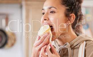 A sweet treat for the chef. a young woman enjoying a baked cupcake.