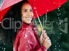 Its raining, its pouring. a beautiful young woman standing in the rain with an umbrella.