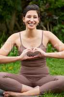 Good health is great nourishment for your body and soul. Portrait of a young woman making a heart shape with her hands while exercising outdoors.