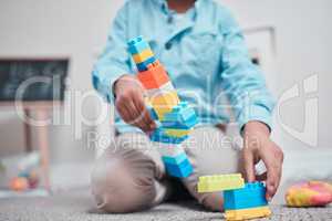 This will keep them entertained for ages. a young boy playing with building blocks in a room.