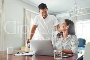 Hows the budget looking. a young couple using a laptop to their household budget in the living room at home.