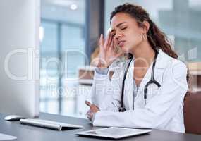 Burnout can cause physical problems. a young female doctor suffering from a headache at work.