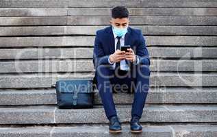 Spending my time missing you. a young businessman sitting on steps using his smartphone.