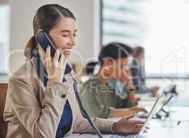 Speaking clearly and professionally to her callers. a young businesswoman talking on a telephone while working in a call centre.