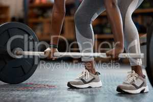 Lift with your legs. an unrecognizable and athletic young woman working out with a barbell in the gym.