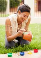 Imagination is the beginning of creation. s young woman painting a pot in the garden at home.