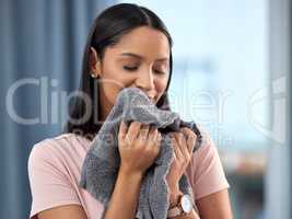 When your environment is clean you feel happy motivated and healthy. a young woman smelling a towel at home.