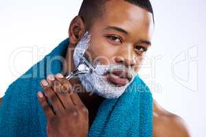 Time to say goodbye to the beard. Studio portrait of a handsome young man shaving against a white background.