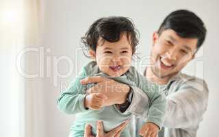 He makes parenting look easy. a young man bonding with his baby at home.