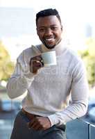 Breathing in that fresh city air. a young businessman enjoying a cup of coffee on his work balcony.