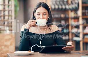 Beautiful, happy and relaxed student with tablet drinking coffee, listening to a podcast and music on earphones in a cafe. Woman online and watching distance learning education webinar in restaurant