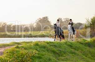 A horse gallops with his lungs,..Perseveres with his heart. two young women riding their horses outside on a field.