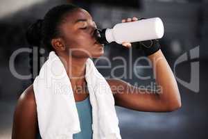 Exercise regularly and drink plenty of water. a fit young woman drinking water while at the gym.