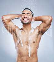 So clean and fresh. Studio shot of a handsome young man taking a shower against a grey background.