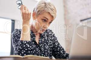 You cant be serious. a mature woman sitting alone and feeling stressed while using her laptop to work from home.