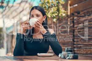 Calm, relaxed and stylish woman taking a coffee break at an outdoor coffee shop in summer. One young entrepreneur or freelancer enjoying her free time drinking tea and relaxing outside