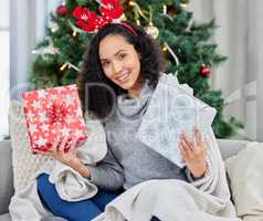 All these gifts, but Im still the best present. a young woman holding up gifts during Christmas time at home.