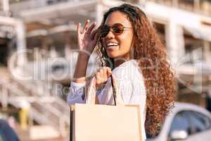 Spending cash like Im a millionaire. an attractive young woman standing alone outside while shopping in the city.