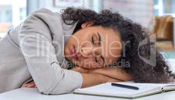 Its difficult to keep up when youre low on energy. a young businesswoman sleeping at her desk in an office.