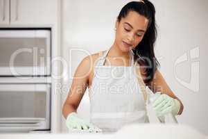 Cleaning can be relaxing. a young woman cleaning a counter at home.