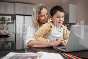 Online schooling is so convenient. a mother and son team using a laptop to complete home schooling work.