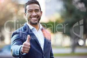 Happiness comes to those who allow it. a handsome young businessman giving the thumbs up.