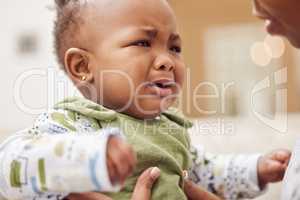 Are you hungry, tired or wet. a baby girl crying while sitting at home.