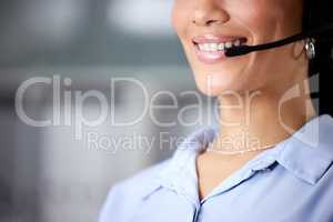 Always answering calls with a smile. an unrecognisable call centre agent wearing a headset in the office during the day.