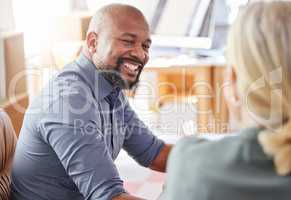 Im always happy to give some advice. a businessman smiling while talking to a colleague.