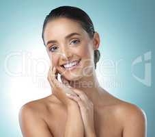 Beauty in perfection. a young female touching a her soft skin against a blue background.