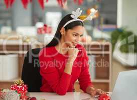 Real ambition doesnt take a break. a young businesswoman using a laptop in a modern office at Christmas.